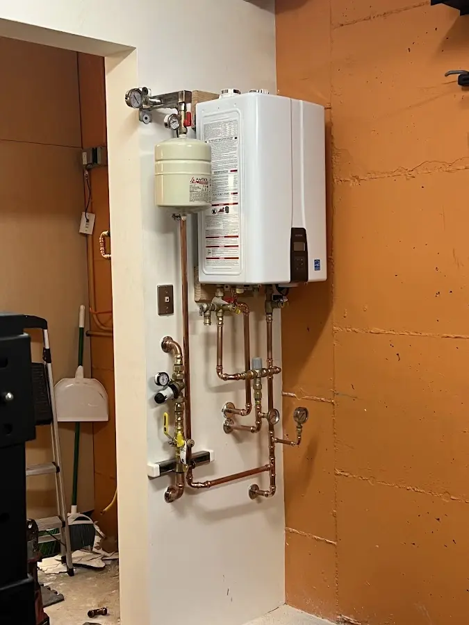 Plumbing technician inspecting water heater connections in Patterson